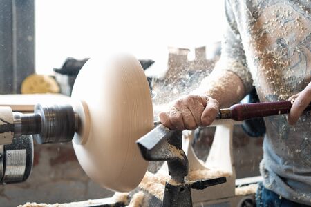 Carpenter working on woodworking machines in carpentry shop. A man works in a carpentry shop.の写真素材