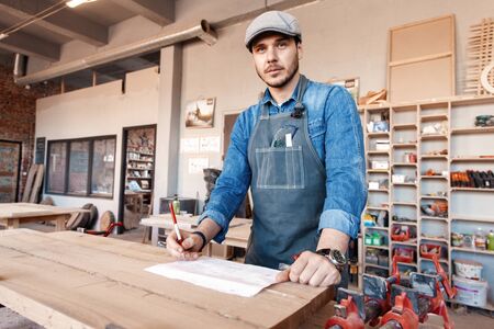 Successful handsome businessman with stylish cap work in carpentryの写真素材