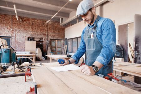 Successful handsome businessman with stylish cap work in carpentry