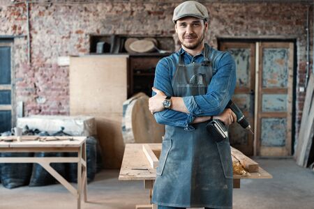 Successful handsome businessman with stylish cap work in carpentryの写真素材