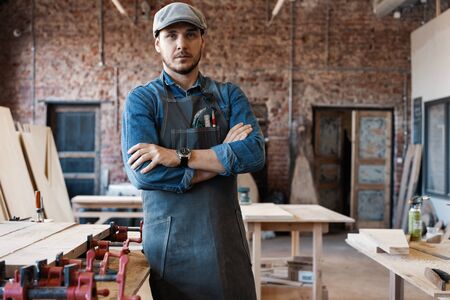 Successful handsome businessman with stylish cap work in carpentryの写真素材