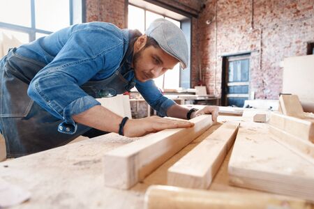 Successful handsome businessman with stylish cap work in carpentryの写真素材