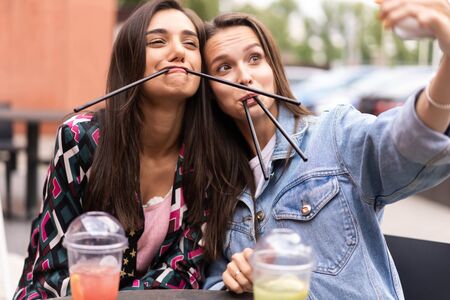 Close up lifestyle selfie portrait of pretty fresh young brunette best friends girls making selfie,...