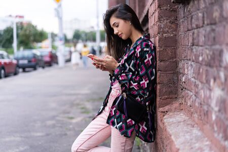 Natural young woman reading an sms or text message on a mobile phoneの写真素材