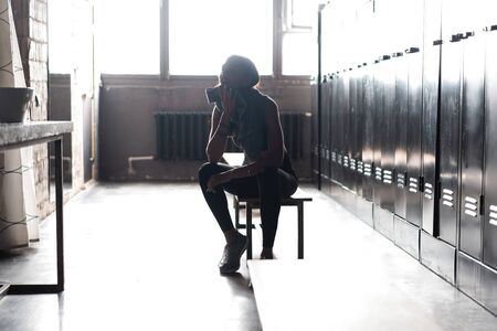 Caucasian female athlete preparing for a workout in a gym locker room.の写真素材