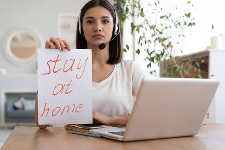 Beautiful young woman working on laptop from home office space in quarantine