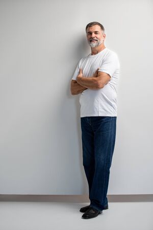 Portrait of smiling mature man standing on white background.の写真素材