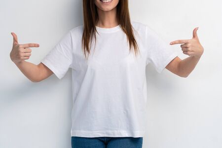 Portrait of a smiling woman holding copyspace on the palm isolated on a white background.の写真素材