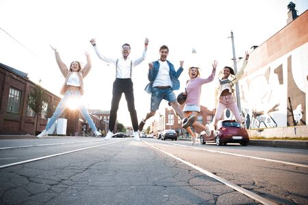 Group of young people having fun together outdoors in urban background.