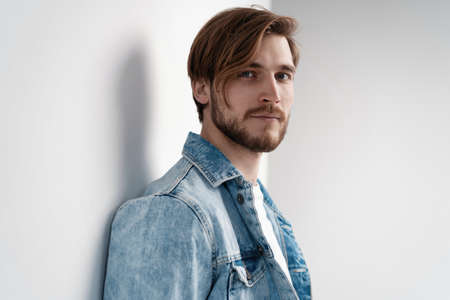 Fashion portrait of young man wearing jeans jacket.