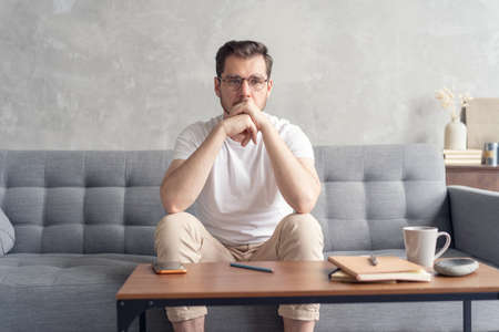 Thoughtful pensive handsome male student thinking about new idea or project analysing planning...