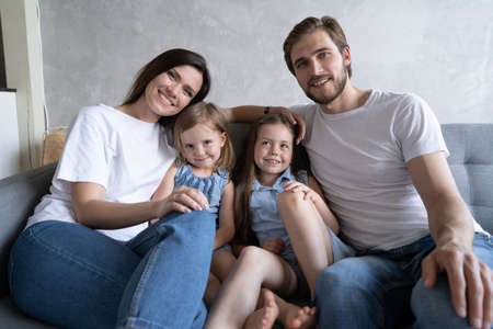 Cheerful family at home sitting in sofa.