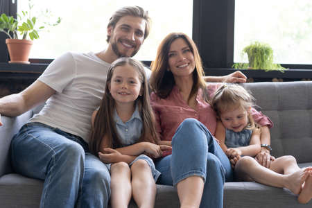 Cheerful family at home sitting in sofa.