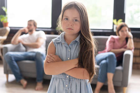 Closeup of a sad girl while parents quarreling in the home.