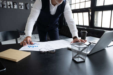 Pensive handsome matured confident businessman in trendy formal wear checking accounting report