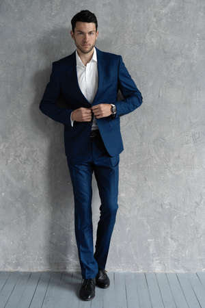 full length of handsome man wear blue suit isolated on grey background.の写真素材