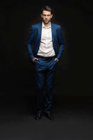 Handsome man wear blue suit isolated on black background.の写真素材