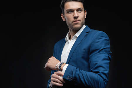 Handsome man wear blue suit isolated on black background.