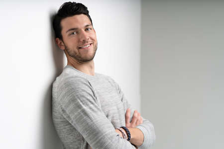 Handsome young man on white background looking at camera. Happy guy smiling