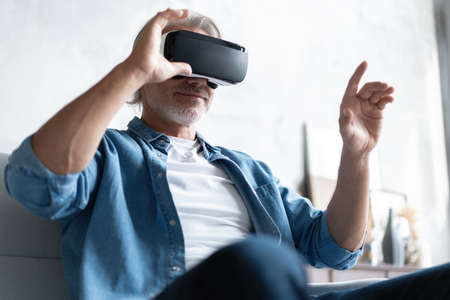 Handsome man trying vr glasses at home.の写真素材