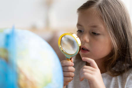 education and school concept. child girl pointing at globe.の写真素材