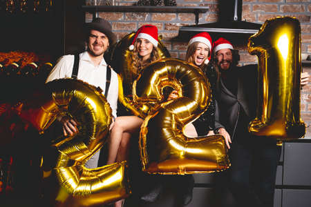 Party, people and new year holidays concept - women and men celebrating new years eve 2021.