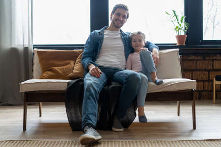 Portrait of handsome father and his cute daughter hugging and smiling.の写真素材