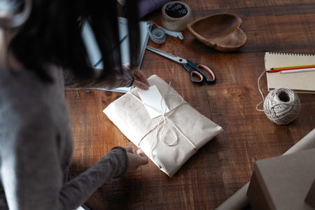 Top view of female business owner working, packing the order for shipping to customer