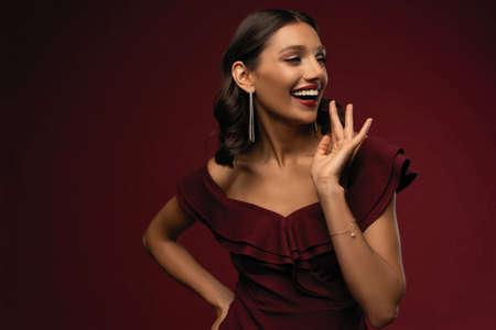 Beautiful model girl with elegant hairstyle in red dress. Woman with red lips and nails.の写真素材