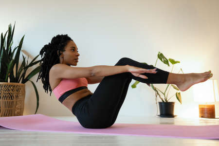 Attractive female doing exercise in her living room. She doing abs. Workout.の写真素材