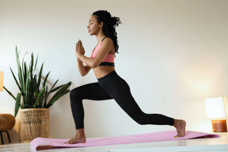 Attractive and healthy young woman doing exercises while resting at home