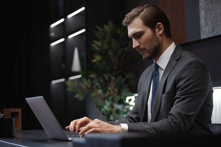 Portrait of young pensive man sitting at his desk in the office