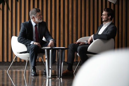 Businessmen discussing deal, sharing startup ideas, business partners negotiations or job interview in modern office, colleagues talking, working on project togetherの写真素材