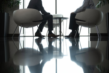Businessmen discussing deal, sharing startup ideas, business partners negotiations or job interview in modern office, colleagues talking, working on project togetherの写真素材