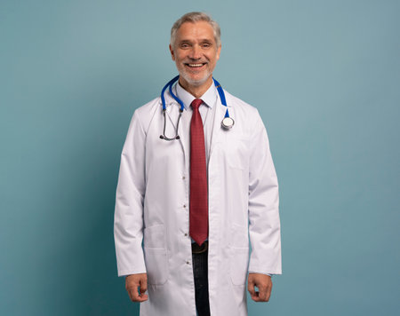 Cheerful mature doctor posing and smiling at camera, healthcare and medicine.の写真素材
