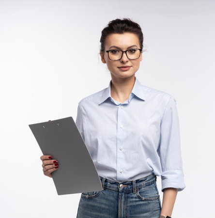 Cheerful brunette business woman in shirt, smiling confident and cheerful with folder, isolated on a white backgroundの写真素材