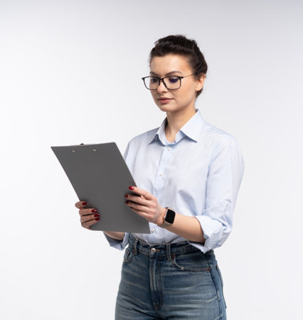 Cheerful brunette business woman in shirt, smiling confident and cheerful with folder, isolated on a white backgroundの写真素材