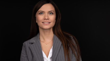 Portrait of smiling business woman on black background
