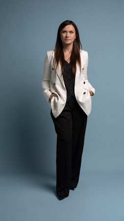 Full length of beautiful, attractive, middle aged woman wearing casual white jacket standing...