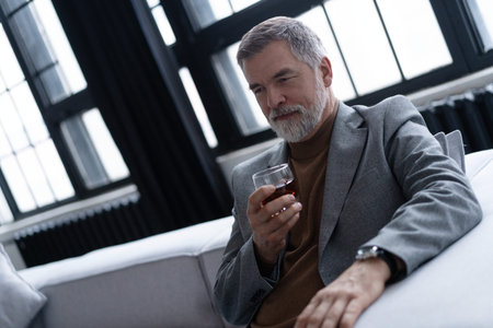 Confident mature businessman chilling relaxing drinking enjoying whiskey after work