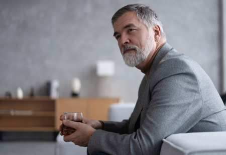 Confident mature businessman chilling relaxing drinking enjoying whiskey after work