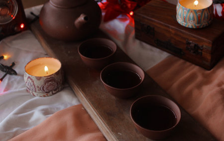 Cup of tea and candles on wooden tray, close-upの写真素材