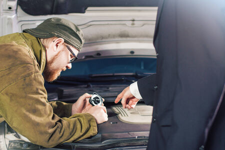 Man in Suit Pointing Motor Oil Slot for Mechanicの写真素材