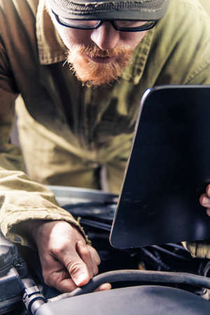 Mechanic Holding Document Holder Checking Hose Integrity