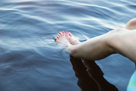 Woman Dipping Feet into Soothing Fresh Waterの写真素材
