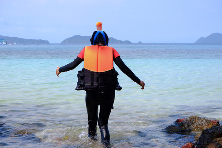 Asian girl in diving suit on the White sand beach. with beautiful sea at Gulf of Thailand. at summer time.の写真素材