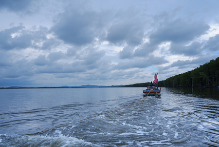 Fisherman sail during sunset in the village. Beautiful seascape horizon and sky.の写真素材