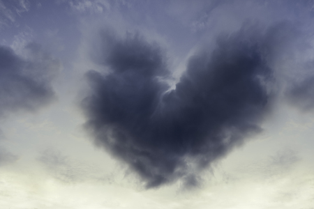 Heart shaped cloud on overcast sky.