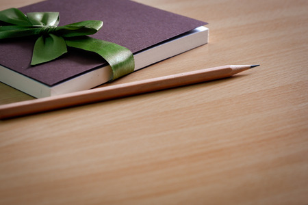 Book diary for gifts to give souvenirs and pencils placed on wooden table.