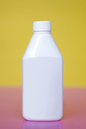 Plastic medicine bottle on the table, yellow background, white packagingの写真素材